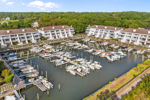 birds eye view of property featuring a water view and a wooded view