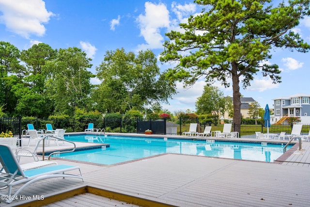 community pool with a patio and fence