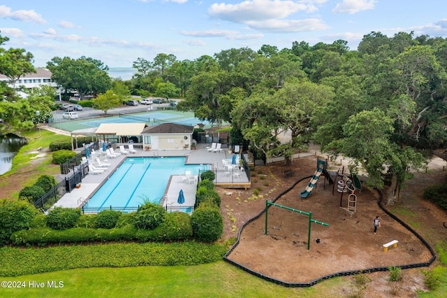 pool with a patio area, fence, and playground community