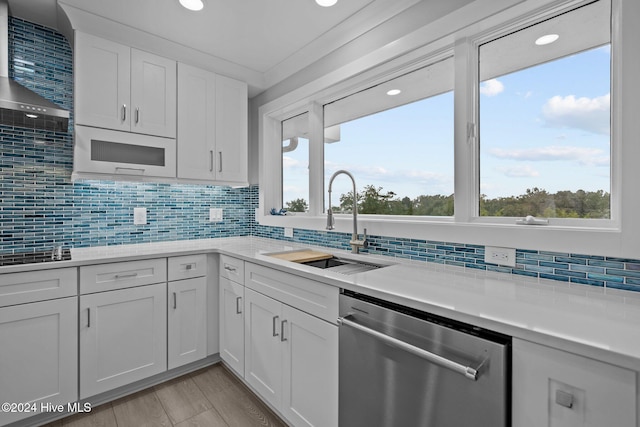 kitchen with decorative backsplash, dishwasher, light countertops, white cabinetry, and a sink