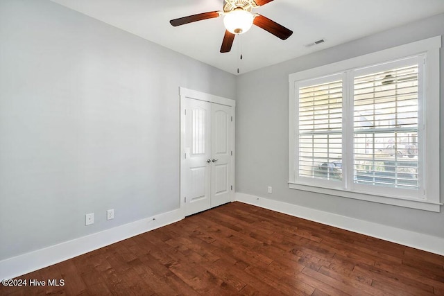 unfurnished room with ceiling fan and dark wood-type flooring