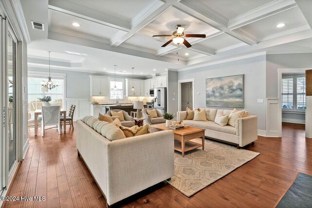 living room featuring ornamental molding, dark hardwood / wood-style flooring, and a healthy amount of sunlight