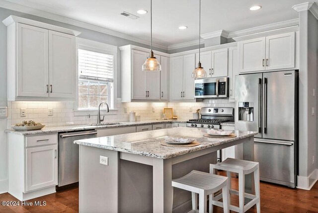 kitchen with white cabinets, decorative light fixtures, stainless steel appliances, and sink