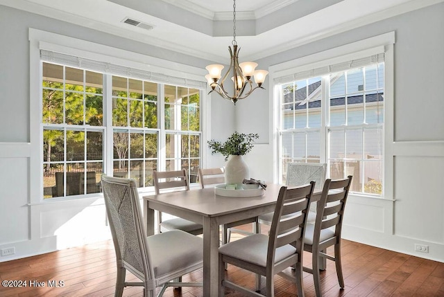 dining space with a healthy amount of sunlight, wood-type flooring, and ornamental molding