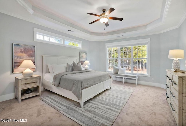 bedroom featuring light colored carpet, a raised ceiling, ceiling fan, and crown molding