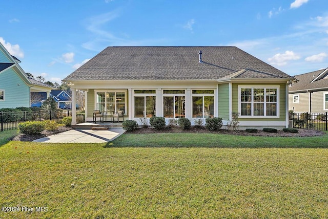 rear view of property featuring a lawn and a patio