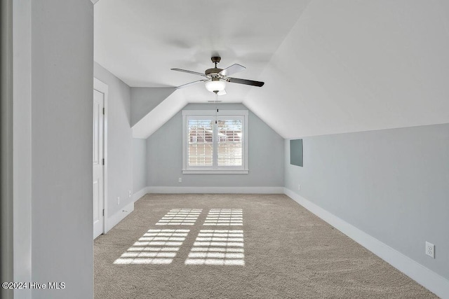 additional living space with light colored carpet, vaulted ceiling, and ceiling fan