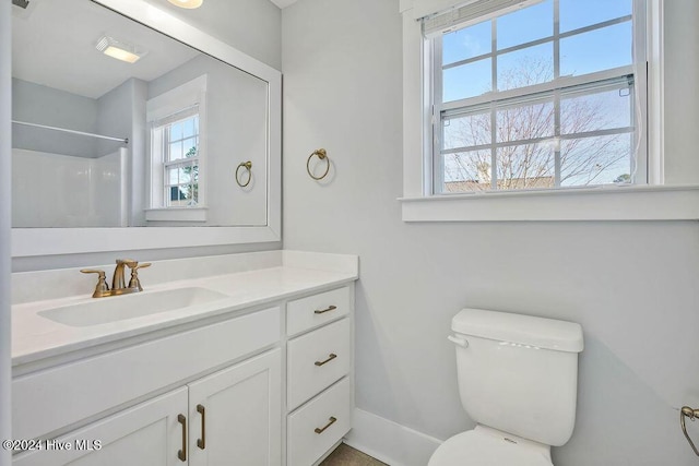 bathroom featuring vanity, toilet, and a shower