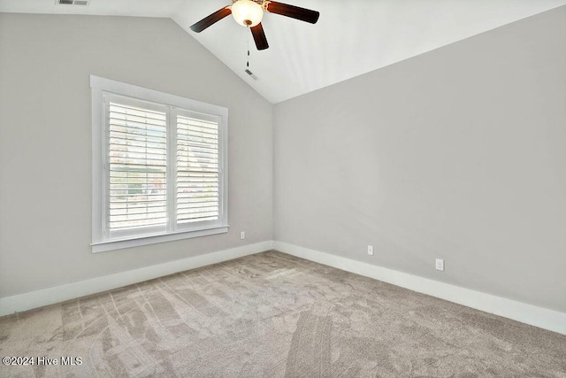 spare room with ceiling fan, light carpet, and vaulted ceiling