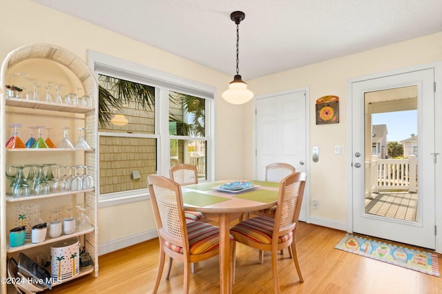 dining area with wood-type flooring and a healthy amount of sunlight