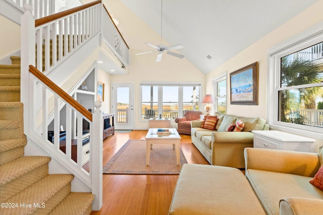 living room featuring high vaulted ceiling, light hardwood / wood-style flooring, and ceiling fan