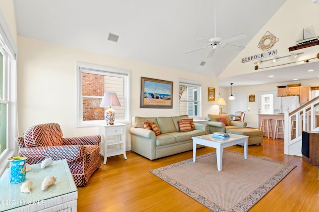 living room featuring ceiling fan, light hardwood / wood-style flooring, and high vaulted ceiling