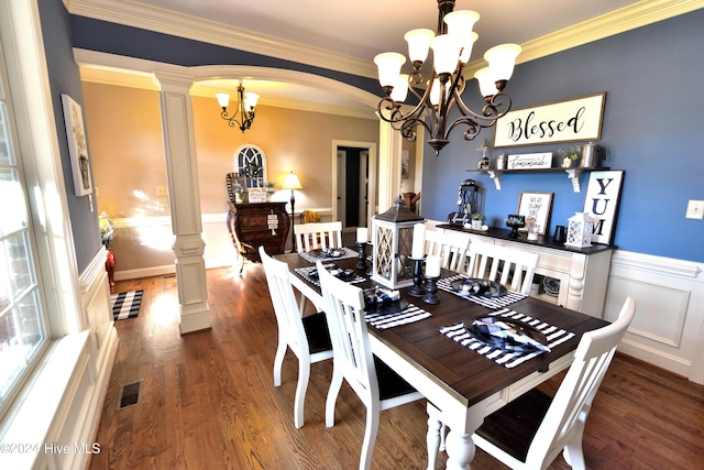 dining area with dark hardwood / wood-style flooring, crown molding, a chandelier, and ornate columns