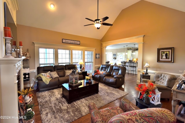 living room with hardwood / wood-style flooring, ceiling fan, and high vaulted ceiling