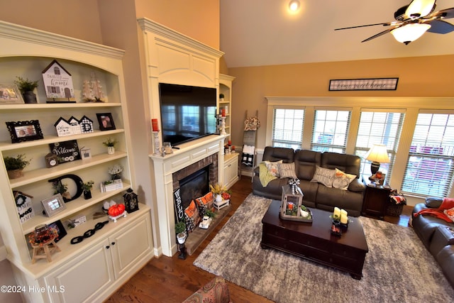 living room featuring built in shelves, a fireplace, dark hardwood / wood-style floors, and ceiling fan