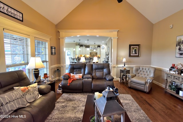 living room with decorative columns, high vaulted ceiling, and dark hardwood / wood-style flooring