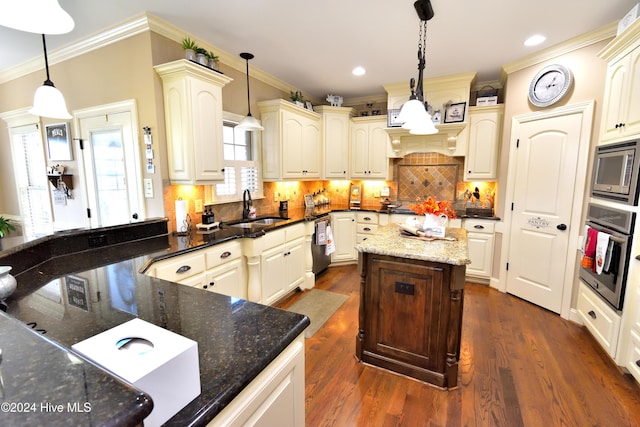 kitchen with dark stone countertops, sink, and decorative light fixtures