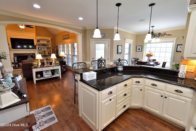 kitchen featuring pendant lighting, a wealth of natural light, decorative columns, and white cabinets