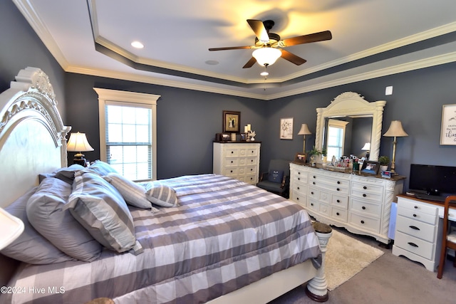 carpeted bedroom featuring crown molding, ceiling fan, and a raised ceiling