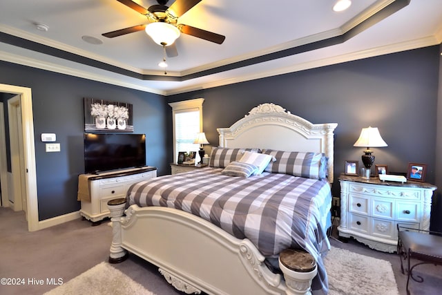 carpeted bedroom with ornamental molding, ceiling fan, and a tray ceiling