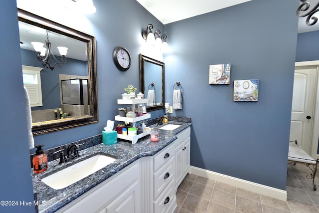 bathroom with tile patterned flooring, vanity, and a notable chandelier