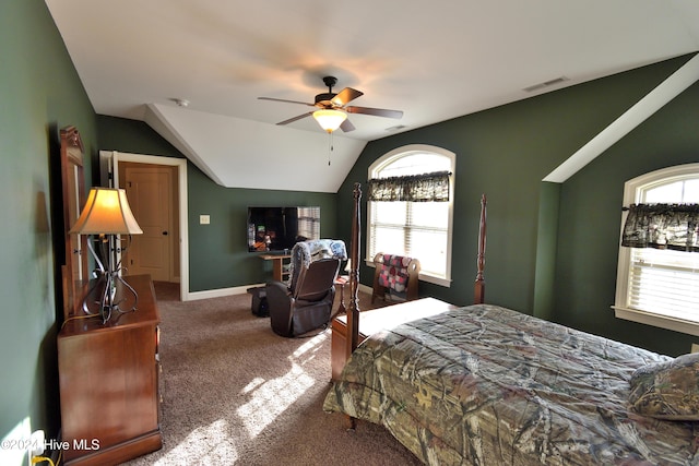 carpeted bedroom with multiple windows, vaulted ceiling, and ceiling fan