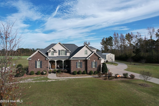 view of front of home with a front yard, a storage unit, and covered porch