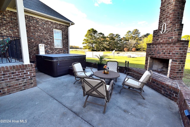 view of patio with an outdoor brick fireplace and a hot tub