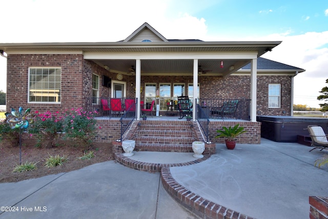 exterior space with a hot tub, a patio, and covered porch