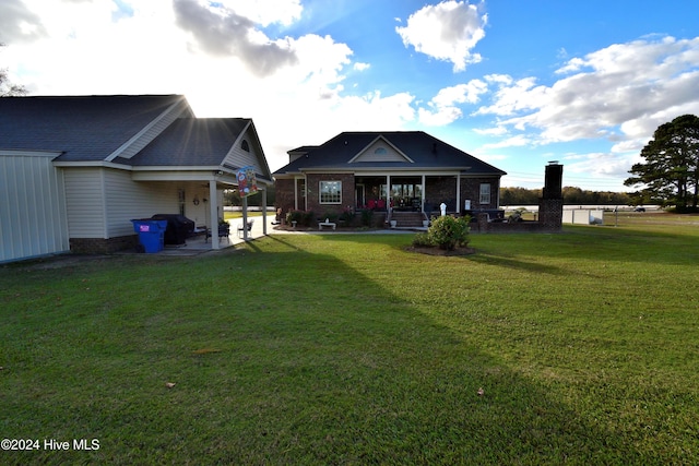 rear view of property featuring a yard