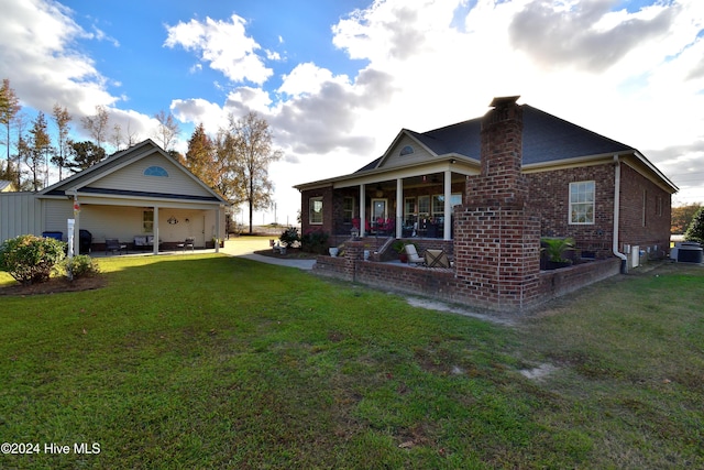 view of property exterior featuring central AC unit, a lawn, and a patio