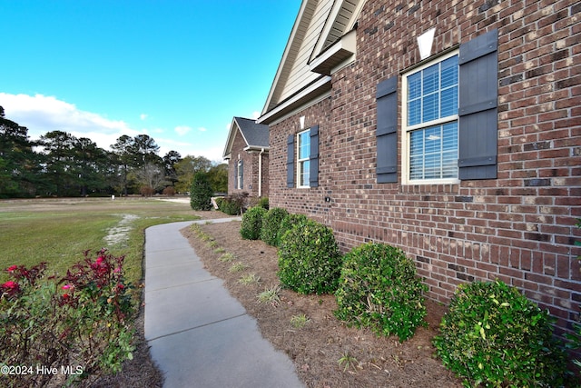 view of side of home with a yard