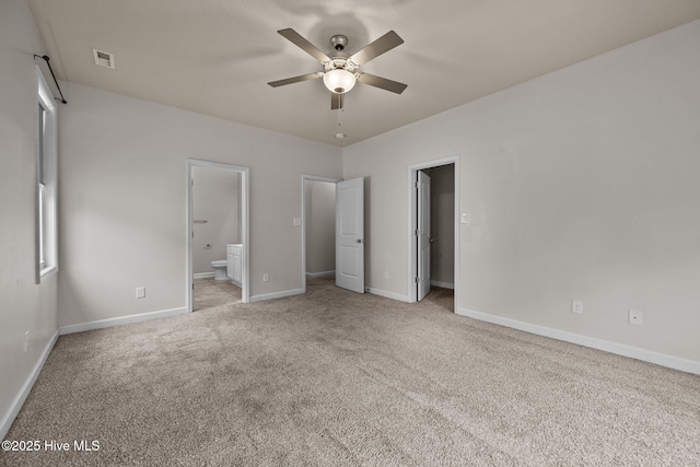 unfurnished bedroom with connected bathroom, ceiling fan, and light carpet