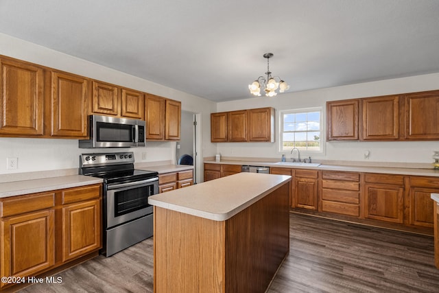 kitchen with stainless steel appliances, sink, decorative light fixtures, a center island, and dark wood-type flooring