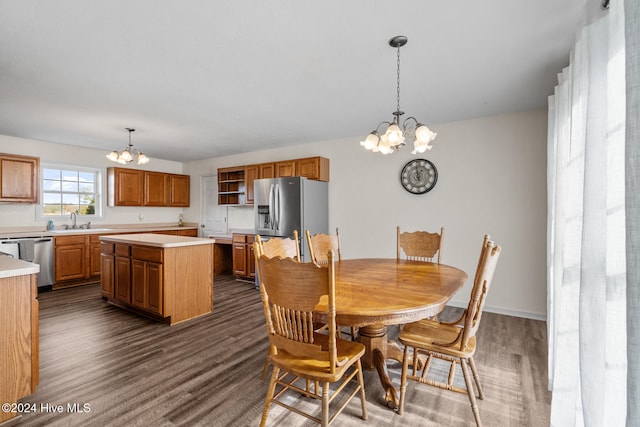 dining area with sink, an inviting chandelier, and dark hardwood / wood-style flooring