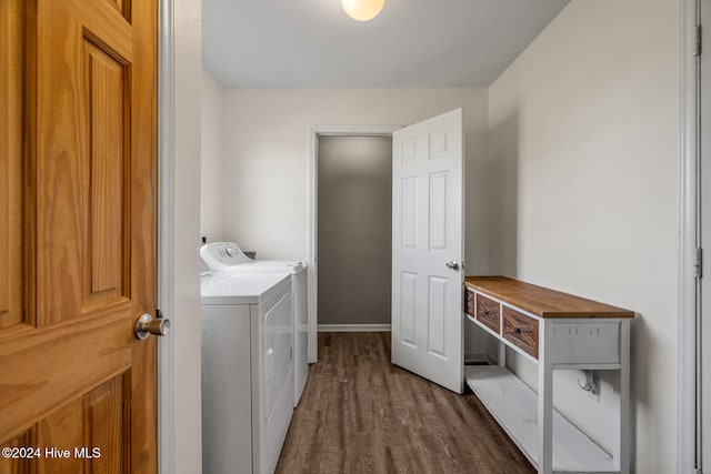 laundry room with separate washer and dryer and dark hardwood / wood-style flooring