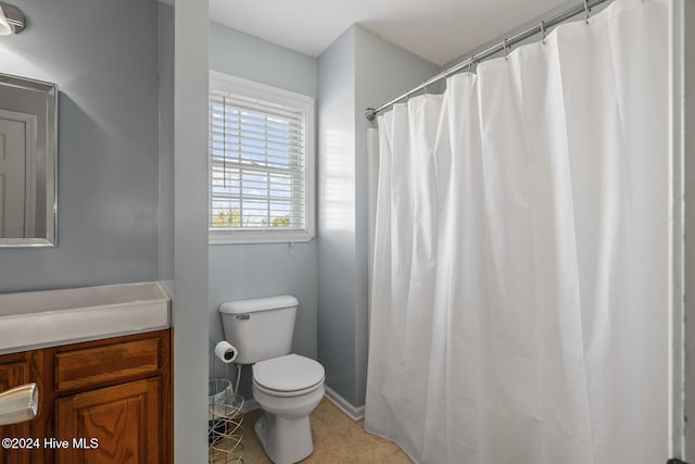 bathroom featuring toilet, vanity, a shower with shower curtain, and tile patterned floors