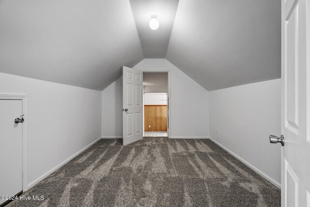 bonus room with lofted ceiling and dark carpet