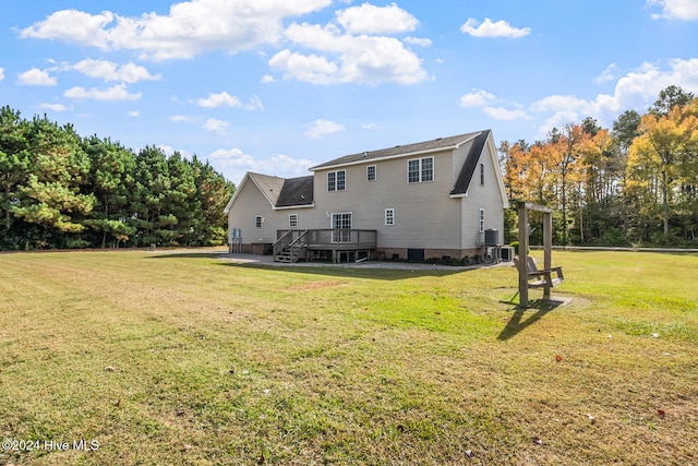 rear view of house with a wooden deck and a yard