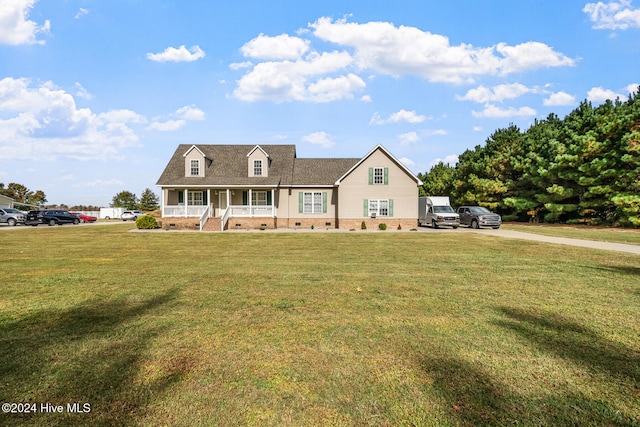 cape cod home featuring a front yard and covered porch