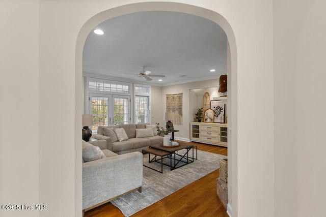 living area with recessed lighting, a ceiling fan, arched walkways, and wood finished floors