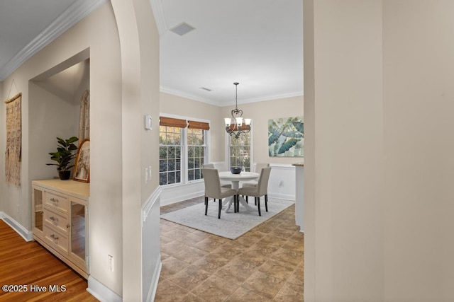 dining area with an inviting chandelier and ornamental molding