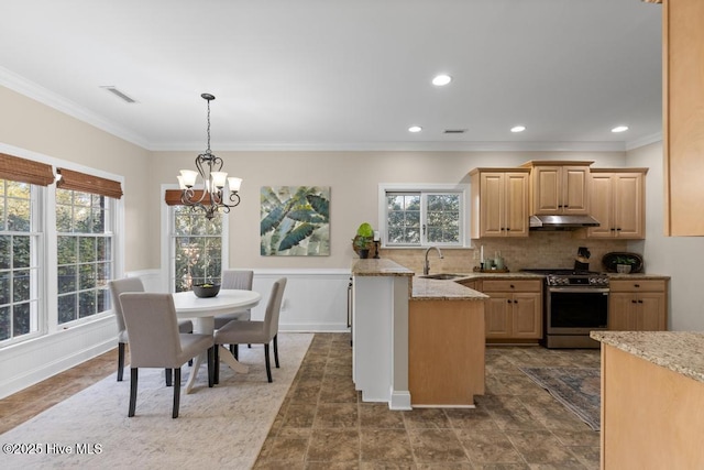 kitchen with sink, light stone counters, decorative backsplash, stainless steel range with gas cooktop, and light brown cabinets