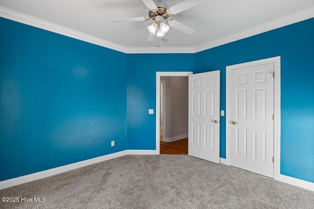 unfurnished bedroom featuring ornamental molding, baseboards, a ceiling fan, and carpet flooring