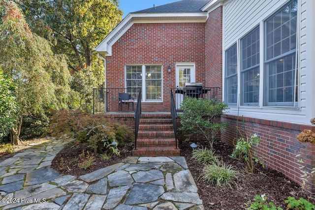 view of exterior entry with brick siding