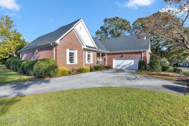 view of front of property with driveway, a front yard, a garage, and brick siding