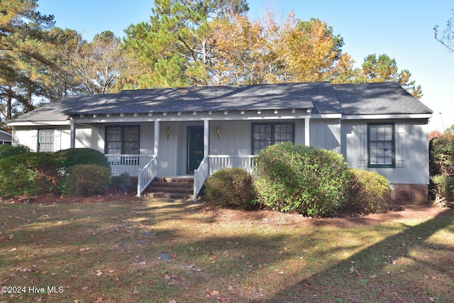 ranch-style home with a porch and a front yard