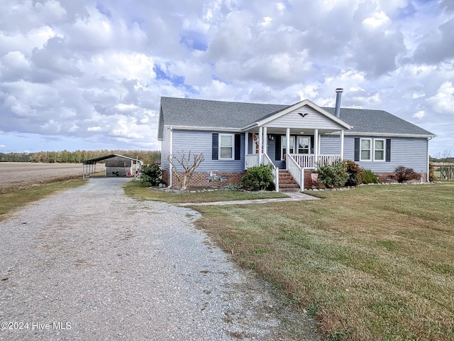 view of front of home with a front yard, a carport, and covered porch