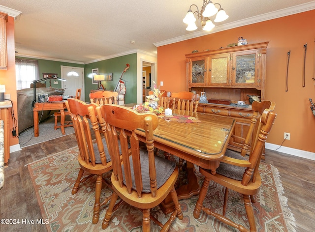 dining room featuring dark wood-type flooring, crown molding, a chandelier, and a textured ceiling