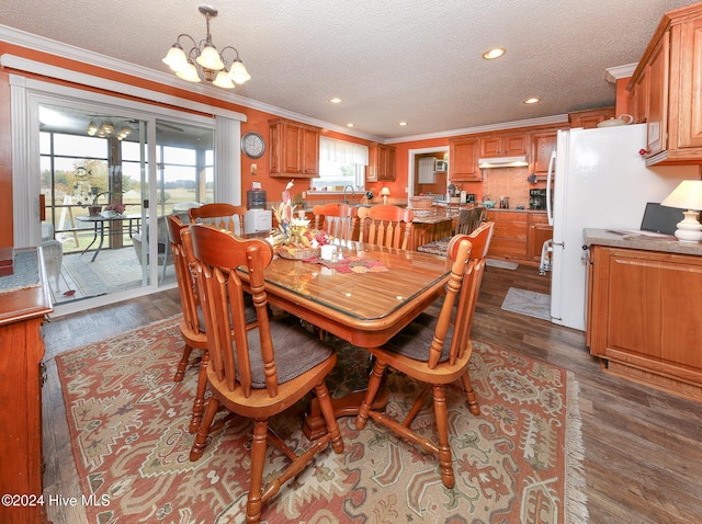 dining space with crown molding, a textured ceiling, a notable chandelier, and dark hardwood / wood-style flooring